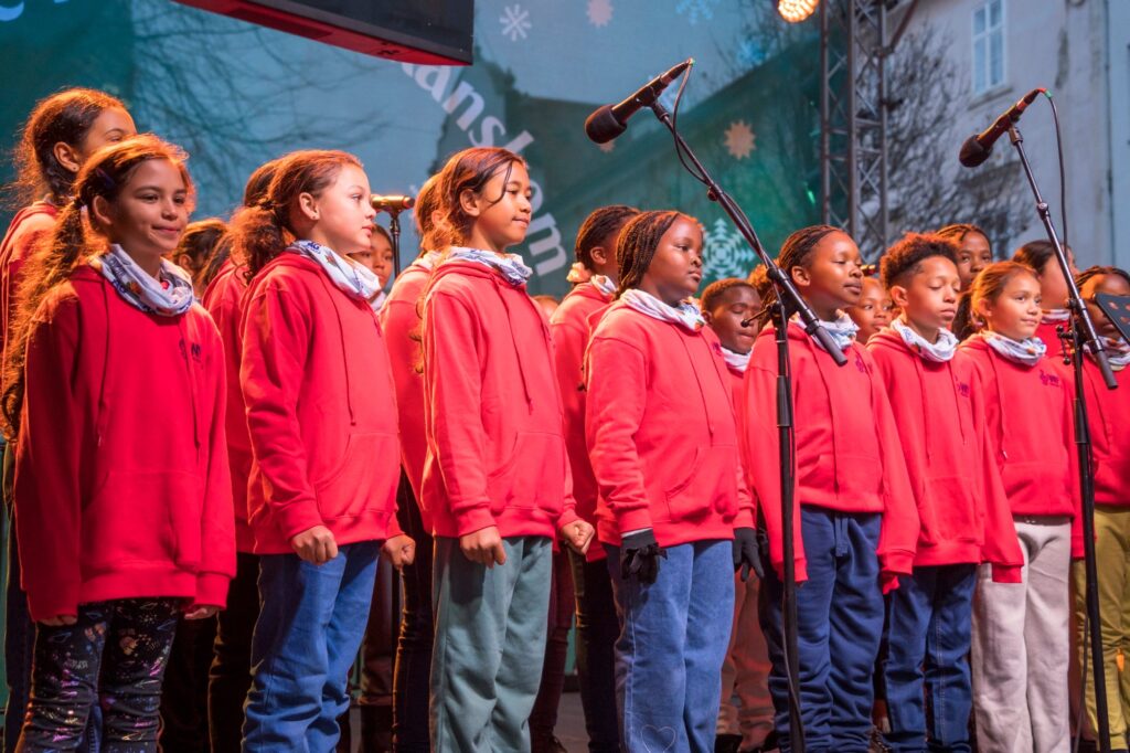 Goodwood Park School Choir, speváci a speváčky - deti v červenom oblečeníi